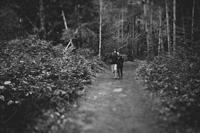 a couple walking arm in arm in the forest