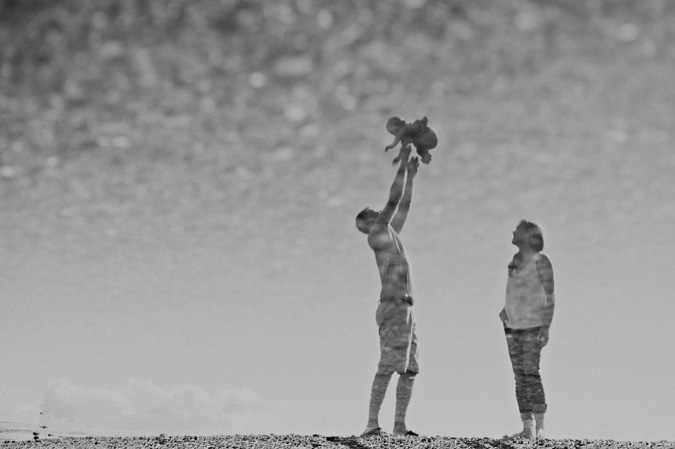 a family reflected in a tidal pool, hornby island, bc