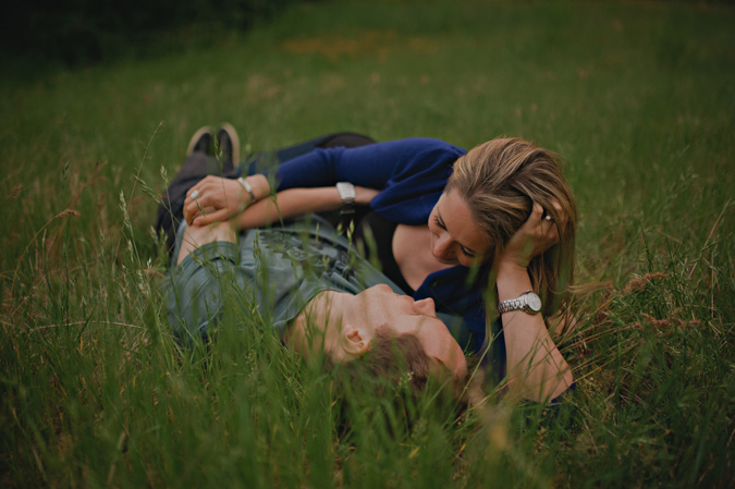 couple lying in the long grass in an open field in comox, bc